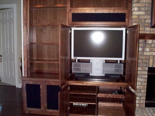 The TV hides behind pocket doors. Note the provision for media storage, equipment and speakers.  The seperate location for the center channel speaker allows CD's to be heard without opening the TV doors.